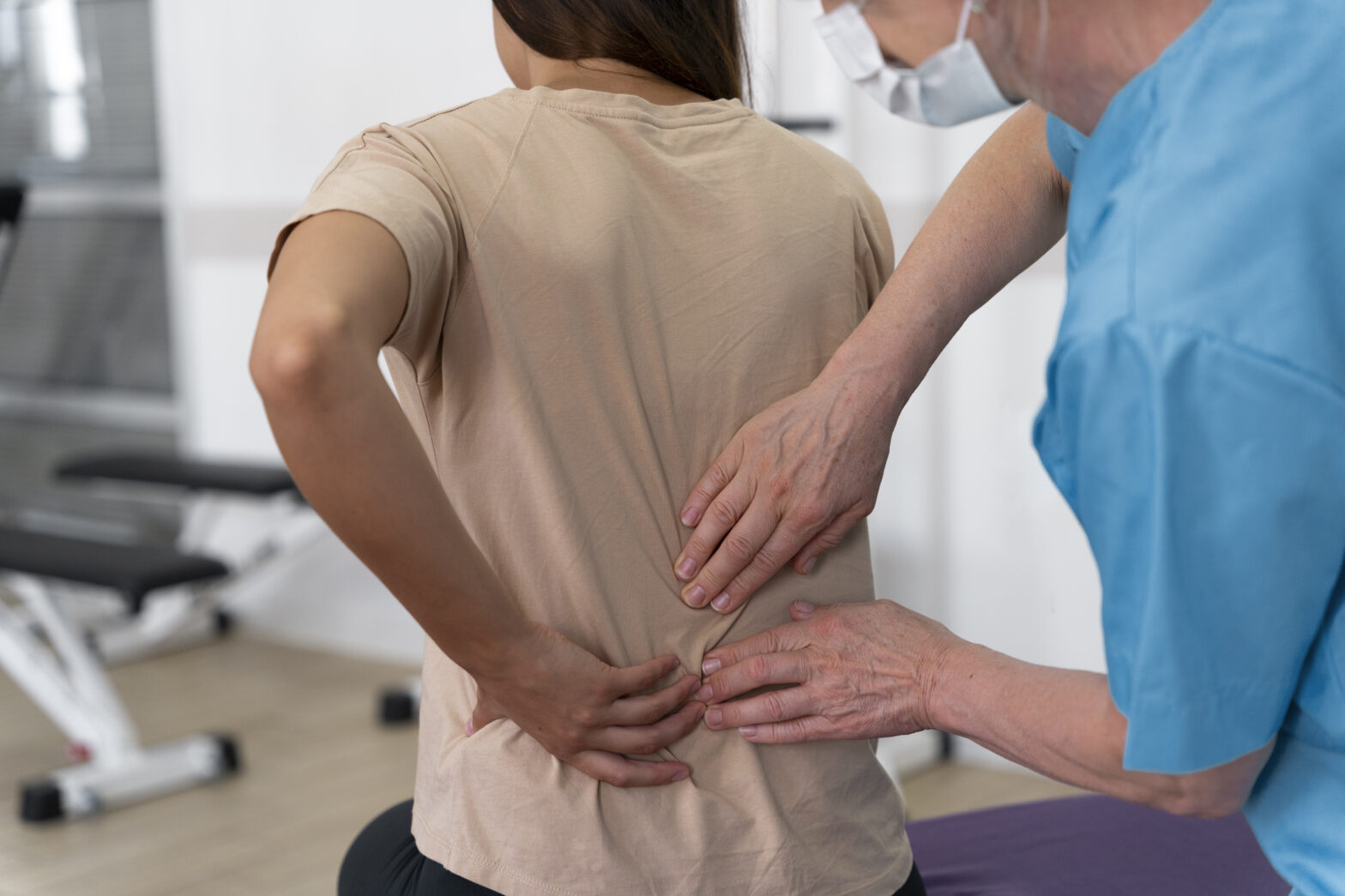 Physiotherapist helping a patient perform back pain physical therapy exercises at Care2Cure Physiotherapy & Rehab Center in Ottawa