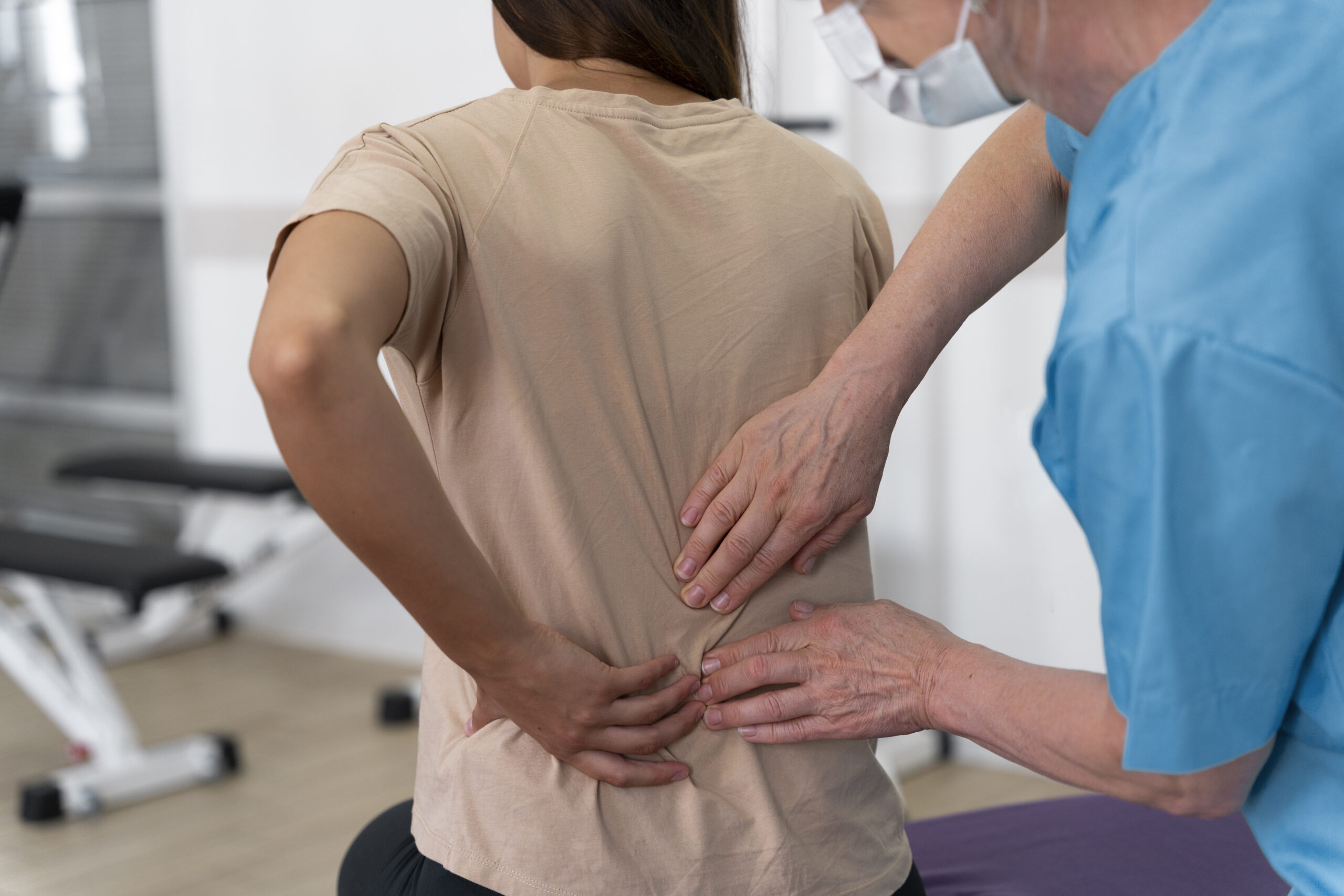 Physiotherapist helping a patient perform back pain physical therapy exercises at Care2Cure Physiotherapy & Rehab Center in Ottawa